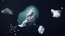 an image of a shrinking iceberg in the center of a dark blue ocean